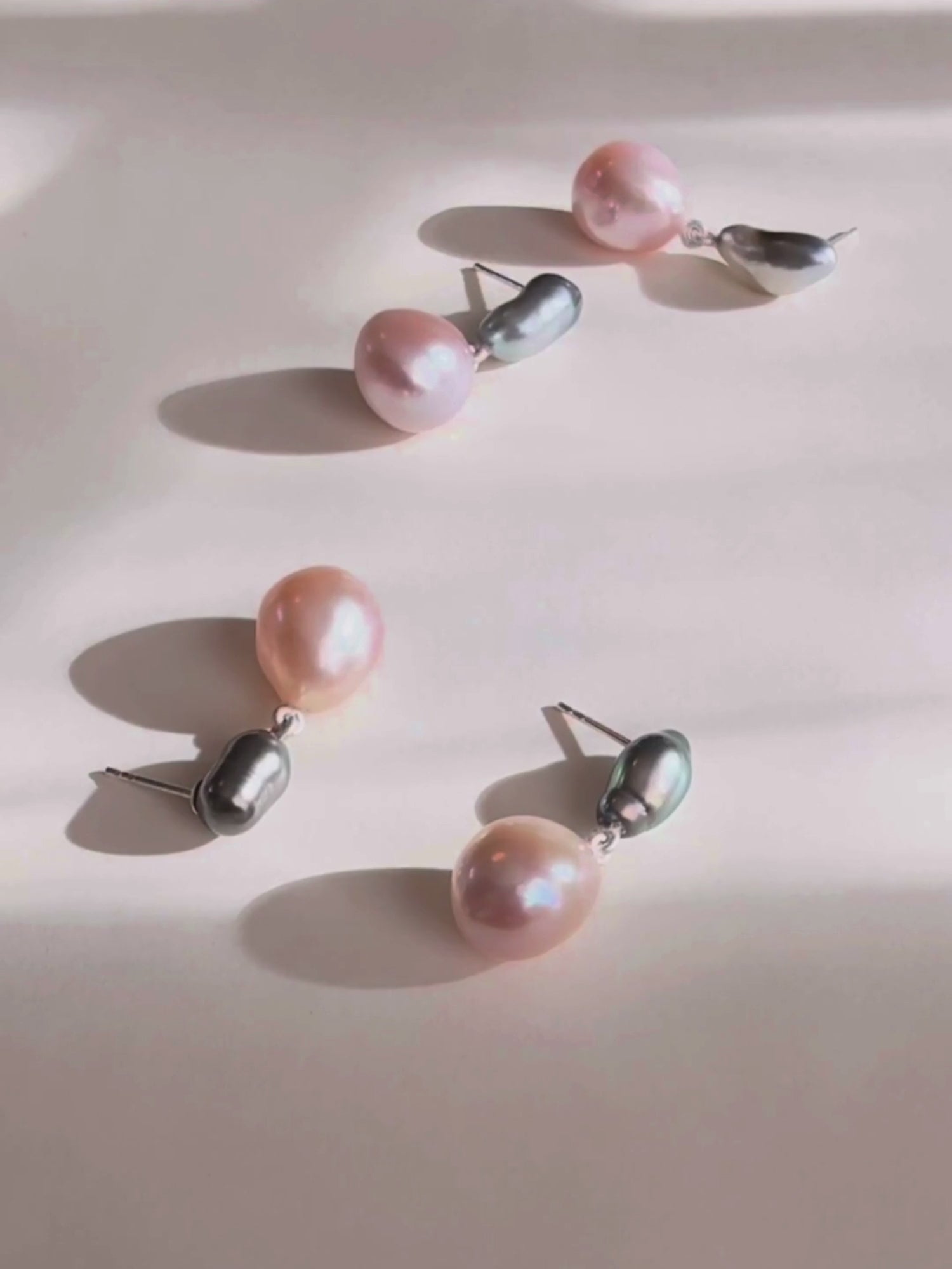 Still video of pearl earrings with conscious Tahiti keshi pearls and pink freshwater pearls in natural light.